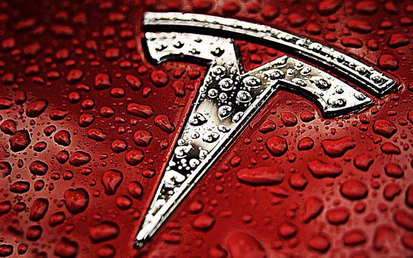 Logotipo de la compañía Tesla con fondo de agua y rojo