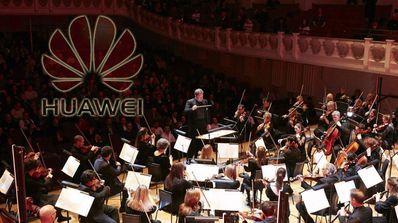 Orquesta con logo Huawei de fondo