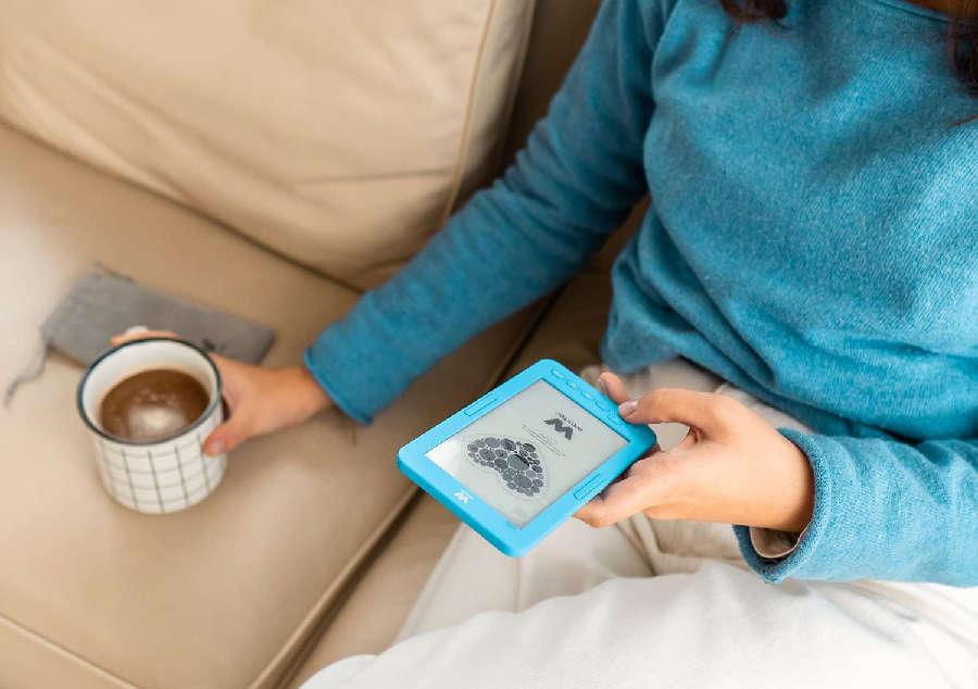 mujer leyendo eBook con café en la mano