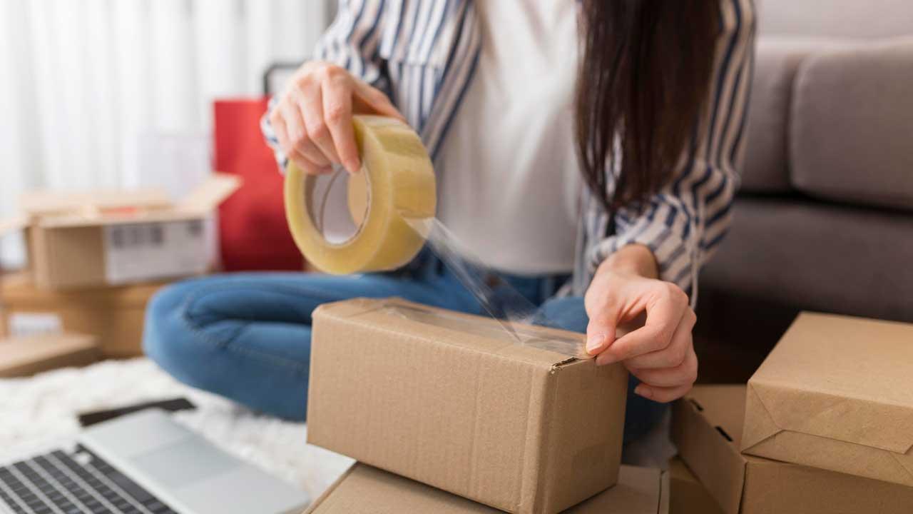 Mujer preparando un paquete para devolver