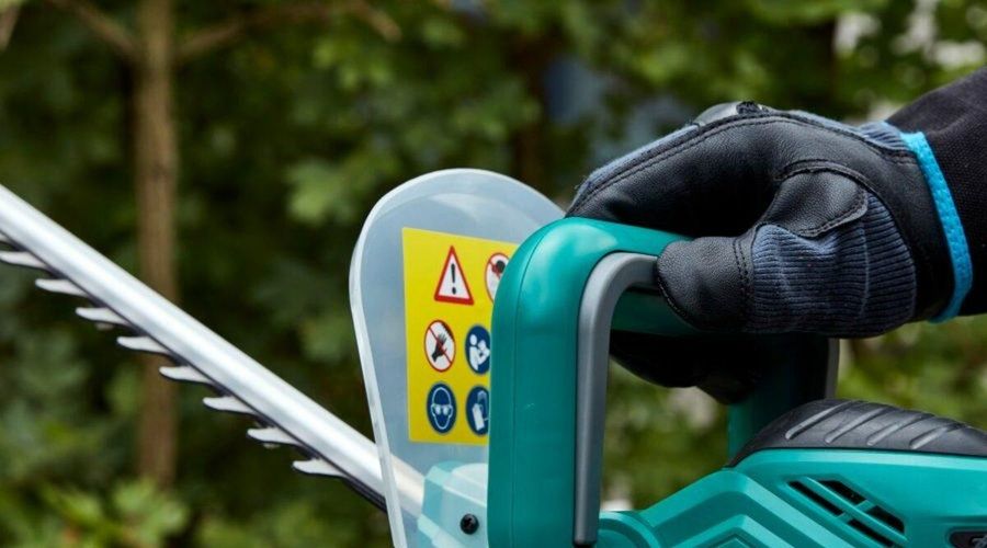Primer plano de un cortasetos FERREX con empuñadura de seguridad y cuchilla de corte