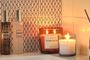 Velas aromáticas encendidas y ambientador con varillas decorando un baño con una iluminación cálida.