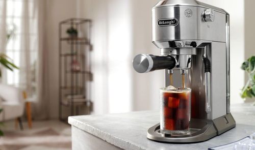 Cafetera espresso manual De'Longhi Dedica Duo preparando un café frío con hielo sobre una encimera de cocina