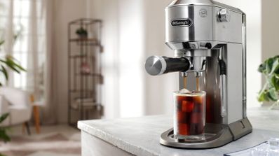 Cafetera espresso manual De'Longhi Dedica Duo preparando un café frío con hielo sobre una encimera de cocina