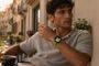 Hombre con un Huawei Watch GT 7 de correa amarilla mientras disfruta de un café en una terraza
