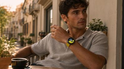 Hombre con un Huawei Watch GT 7 de correa amarilla mientras disfruta de un café en una terraza