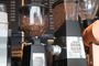 Molinillos de café profesionales con depósitos llenos de granos de café en una cafetería.