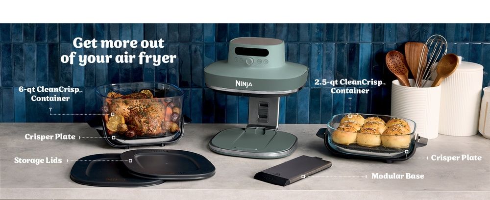 Ninja CRISPi PRO XL junto a sus recipientes de cristal, tapas y accesorios sobre una encimera de cocina.