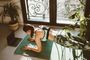 Mujer realizando una plancha sobre una esterilla de ejercicio en casa, junto a una ventana