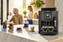 Cafetera superautomática KRUPS Harmony en color carbón preparando dos cafés sobre una encimera de mármol en una cocina moderna