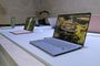 Varios portátiles ASUS Zenbook expuestos sobre una mesa, con un modelo plateado en primer plano y la pantalla encendida