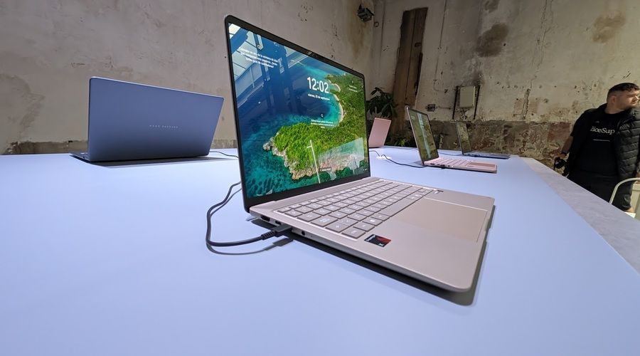 Portátil ASUS Zenbook abierto sobre una mesa, con teclado plateado, pantalla de bordes finos y varios puertos de conexión