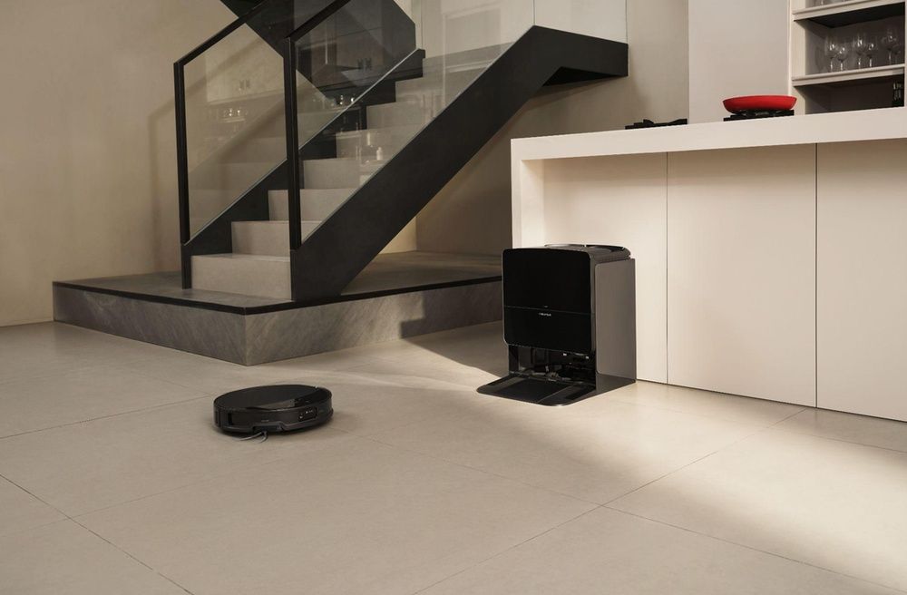 Robot aspirador Roborock junto a su estación de carga y autolimpieza en una vivienda moderna