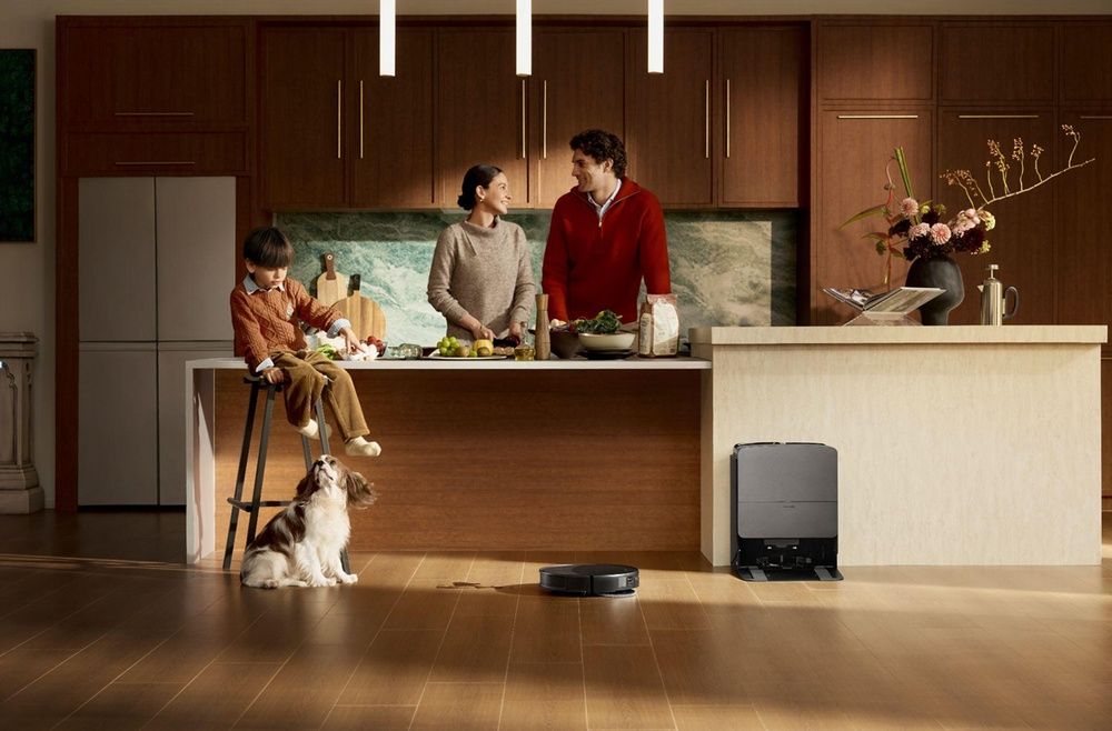 Robot aspirador Roborock y estación de carga en una cocina con una familia y un perro