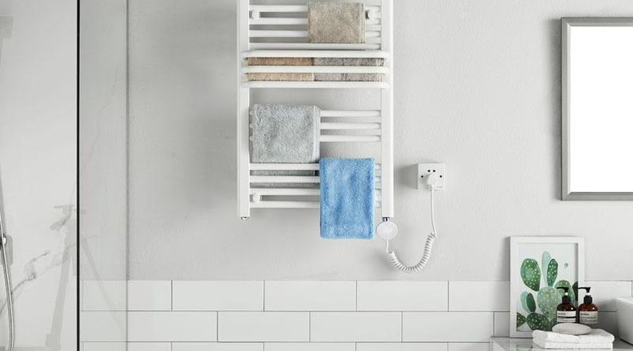 Toallero eléctrico blanco de pared con varias toallas colgadas en un baño moderno