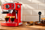 Cafetera exprés roja de estilo retro preparando dos cafés.