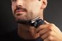Hombre afeitándose el cuello con una afeitadora eléctrica inalámbrica Braun.