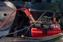 Batería de coche con pinzas rojas y negras conectadas en el compartimento del motor.