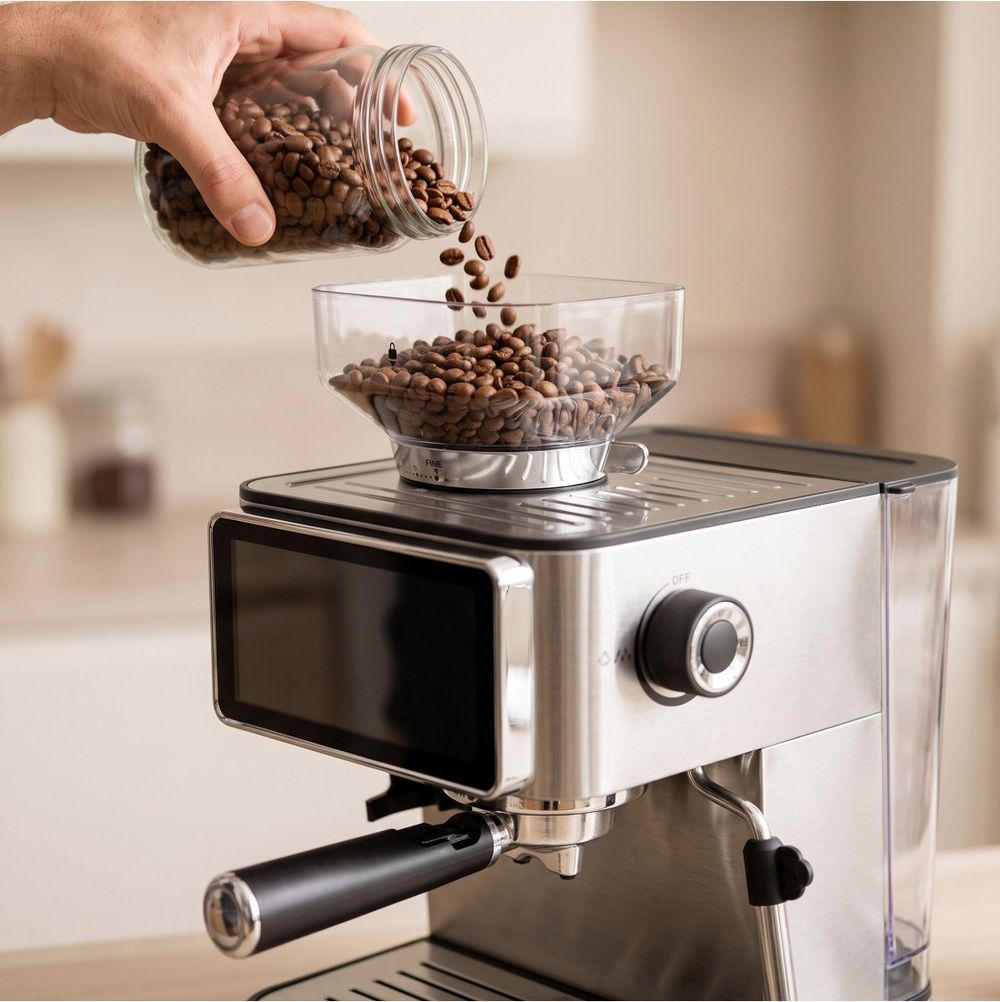 Granos de café introduciéndose en el molinillo integrado de la cafetera JOCCA.