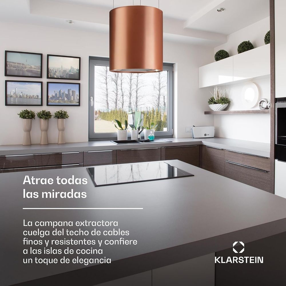 Campana extractora cilíndrica de cobre instalada sobre una isla de cocina.