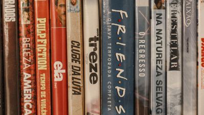 Colección de películas y series en DVD colocadas en una estantería, con los títulos visibles en los lomos.
