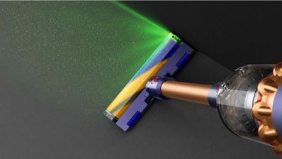 Cepillo de la aspiradora Dyson iluminando el polvo y la suciedad del suelo con luz verde.