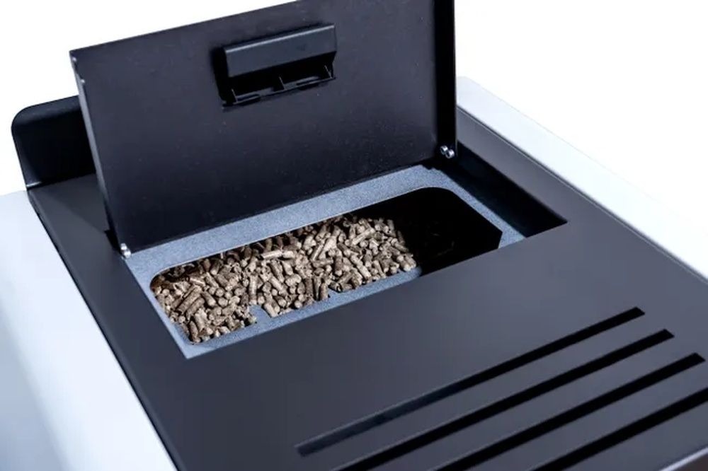 Depósito superior de una estufa abierto y lleno de pellets de madera.