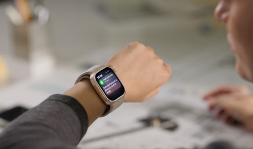 Huawei Watch D3 con correa beige en la muñeca de una persona, mostrando una notificación.
