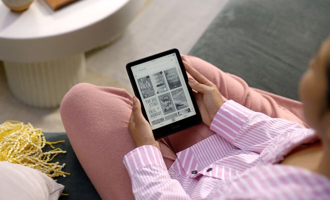 Persona utilizando un Amazon Kindle para elegir un libro electrónico.