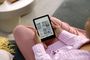 Persona utilizando un Amazon Kindle para elegir un libro electrónico.