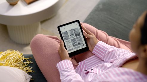 Persona utilizando un Amazon Kindle para elegir un libro electrónico.