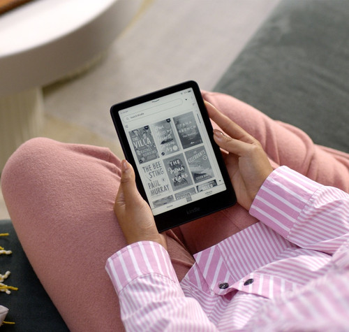 Persona utilizando un Amazon Kindle para elegir un libro electrónico.