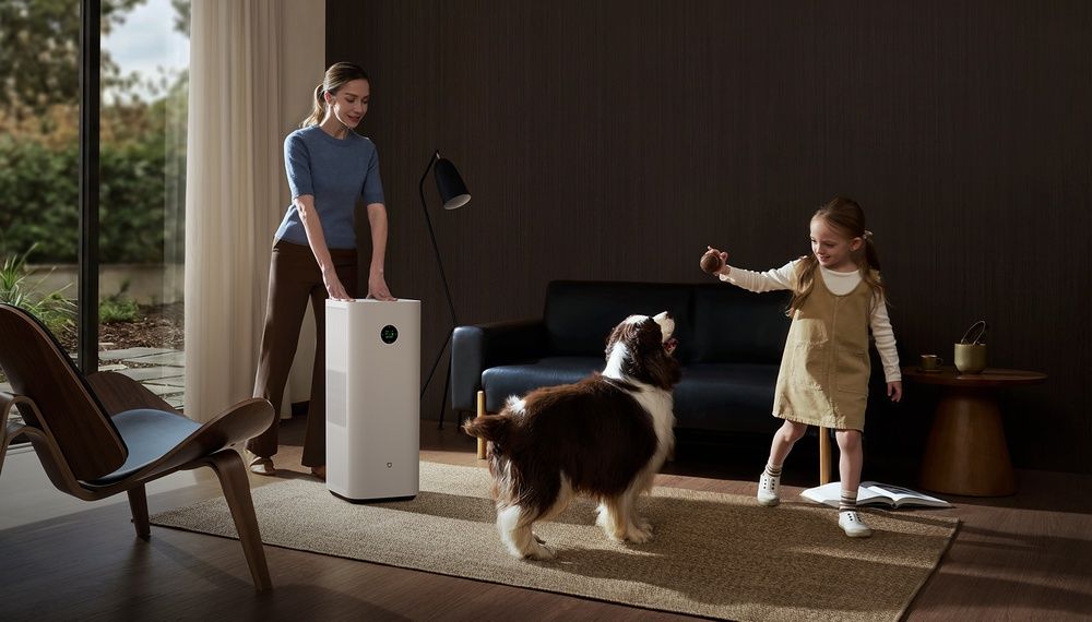 Purificador Mijia Smart Air Purifier 6 Plus en un salón con una mujer, una niña y un perro.