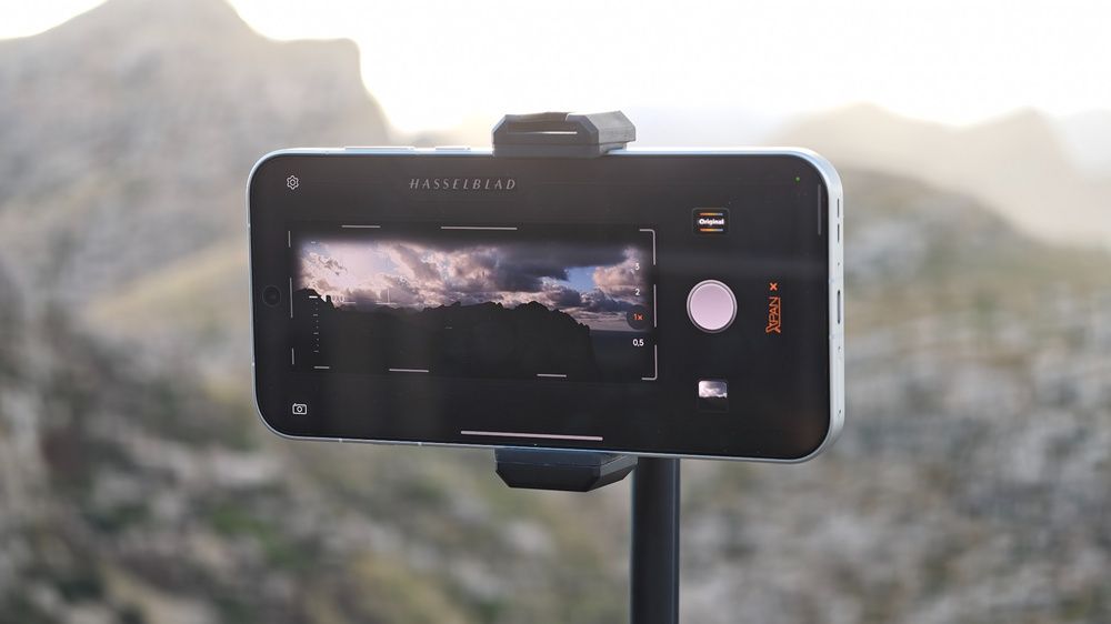 Pantalla de un móvil OPPO sobre un soporte, con la aplicación de cámara abierta para fotografiar un paisaje.