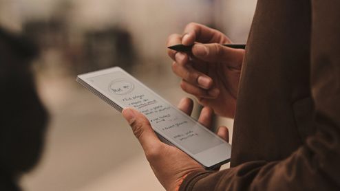 Una persona sostiene un reMarkable Paper Pro Move con notas manuscritas y un lápiz digital en la otra mano.