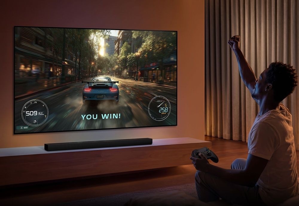 Persona con un mando jugando a un videojuego de carreras en un televisor Samsung S93H.