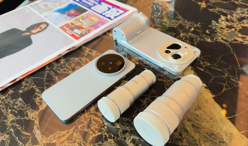 Vivo X500 Pro Max junto a dos objetivos externos y una funda con empuñadura sobre una mesa de mármol.