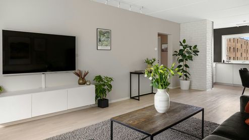 Televisor inteligente de gran formato integrado en un salón moderno y luminoso.