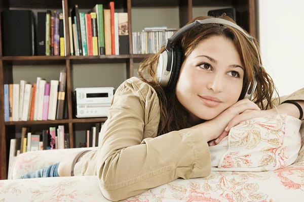 Chica escuchando audiolibro con auriculares